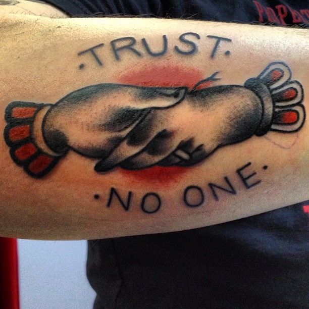 Black trust no one tattoo on upper left hand