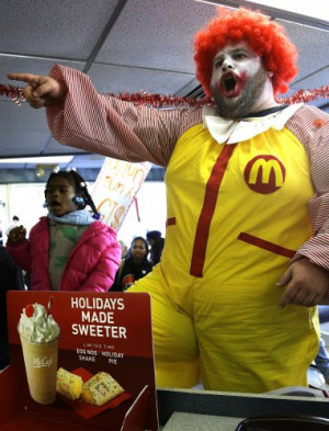 Protesters including a man dressed as Ronald McDonald chant inside a ...