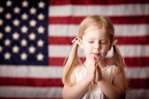 Girl Praying with Flag in Background