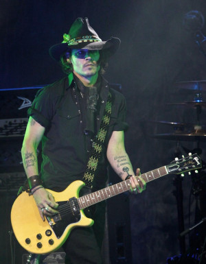 Depp wore an all-black ensemble with an ivory guitar slung low around ...
