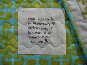 Hand written label, machine appliqued prior to sandwiching/quilting.