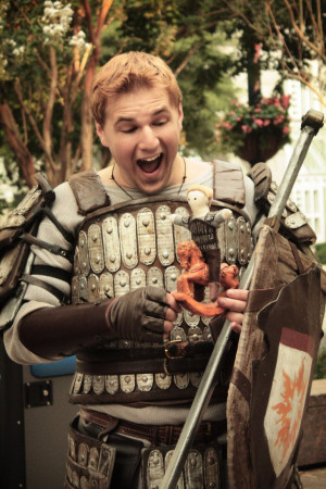 cosplay of Alistair from Dragon Age Origins, playing with a doll of ...