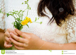 Girl with long hair hold flower in her hand waiting for someone.