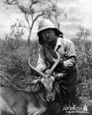 Theodore Roosevelt holding up an Antelope he killed while in Africa.