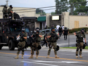 AP Photo/Jeff Roberson Police officers try to disperse a crowd Monday ...
