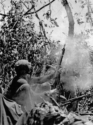 Near the edge of a clearing, a Marine rifleman fires a rifle grenade ...
