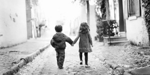 Captured moment of two child friends holding hands.