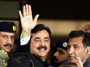 Yousuf Raza Gilani (C) is escorted by security as he waves upon his ...