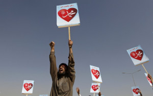 An Afghan protester shouts while holding a sign during a peaceful ...