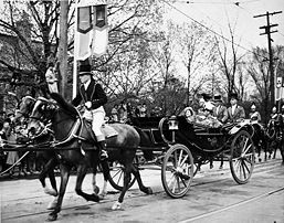 George VI and Queen Elizabeth in a landau with footmen and an outrider ...