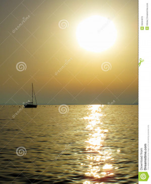 Ship sailing into sunset on the sea. Romantic evening scenery.