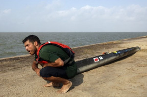 , Andrew Condie, of Cuero, takes a breather while dragging his canoe ...