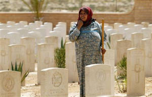 Wife of Mohammed Hamish pauses as she removes weeds from around graves ...