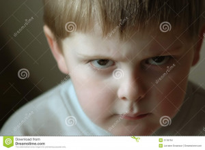 An angry glaring boy, shot in natural light with a shallow depth of ...