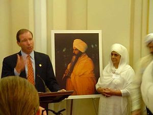 Congressman Tom Udall with Singh's widow, Bibiji. Singh is depicted in ...