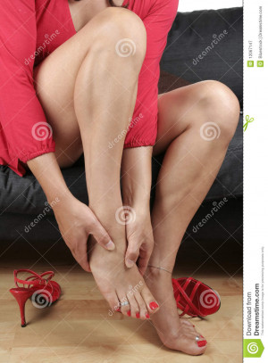 Beautiful woman legs with dress massaging aching feet.