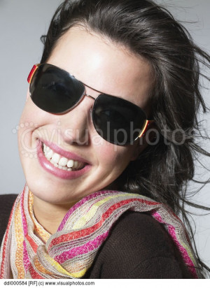 Portrait of smiling young woman in sunglasses on beach - stock photo