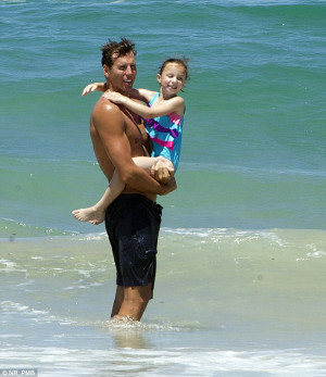 Safe in Dad’s arms: The hulking sportsman looked to be in incredible ...