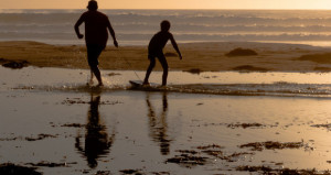 Father and son playing and bonding on Bogey-Board on Morro Stran