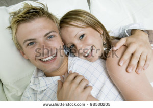 Young Couple Cuddling in Bed - stock photo