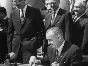 President Lyndon Johnson signs the War on Poverty bill in 1964 ...