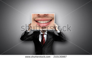Businessman hiding head behind photo with huge mouth - stock photo