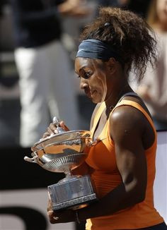 of the United States, holds the trophy after winning her final match ...