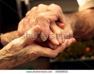 Elderly couple holding hands with love
