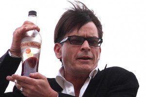 Charlie Sheen drinks from a liquor bottle labeled Tiger Blood and ...