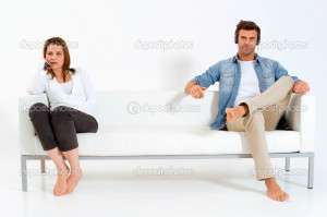 Separated couple on the couch watching TV - Stock Image