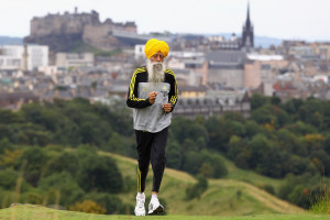 Fauja Singh running in the hills over a city