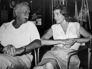 Melvyn Douglas chatting with co-star Patricia Neal on the set during a ...
