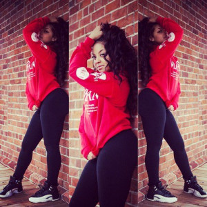 Red oversized hoodie with black leggings. She’s looking super dope