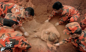 Rescue workers dig around the body of the woman protectively cradling ...