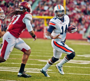 ... Nick Marshall (14) is pursued by Arkansas safety Alan Turner