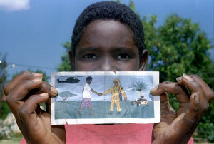 young Somali displays a leaflet dropped by US planes showing an ...