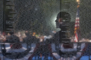 President Barack Obama is reflected in the Vietnam Veterans Memorial ...