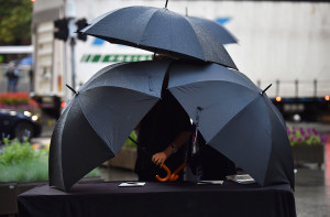 TOPSHOTS Umbrellas protect condolence books for victims of the siege ...