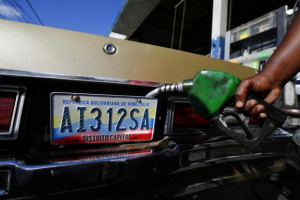 worker fills up a car with fuel at a gas station in Caracas, January ...