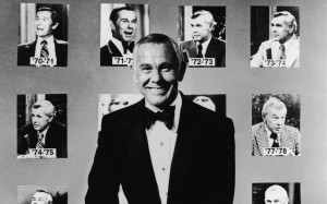 Johnny Carson poses in front of portraits of him from his first twenty ...