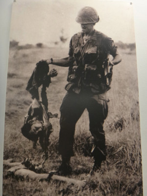 soldier holding the shredded remains of a viet cong soldier
