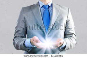 Close up of businessman holding ray of light in palms - stock photo