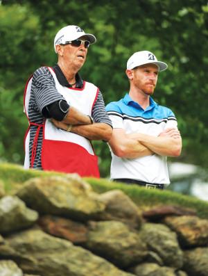 Caddie Jerry Higginbotham and Nick Flanagan watch play on the 11th ...