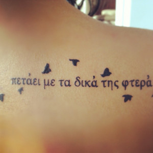 She flies with her own wings tattoo in greek. On shoulder blade ...