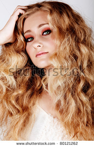 ... blond-woman-with-green-eyes-and-long-big-curly-hair-with-hand-in-hair