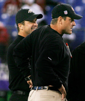 head coach John Harbaugh (L) talks with his brother Jim Harbaugh ...