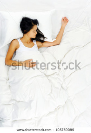 Woman sleeping and resting alone in her bed dreaming view from above