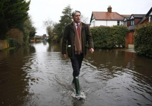 Britain's Defence Secretary Philip Hammond walks along a flooded road ...