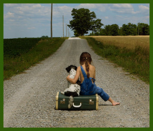 girl sitting with a dog on a suitcase