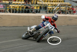 The motorcycle racer in the picture below has a hardened steel ‘shoe ...